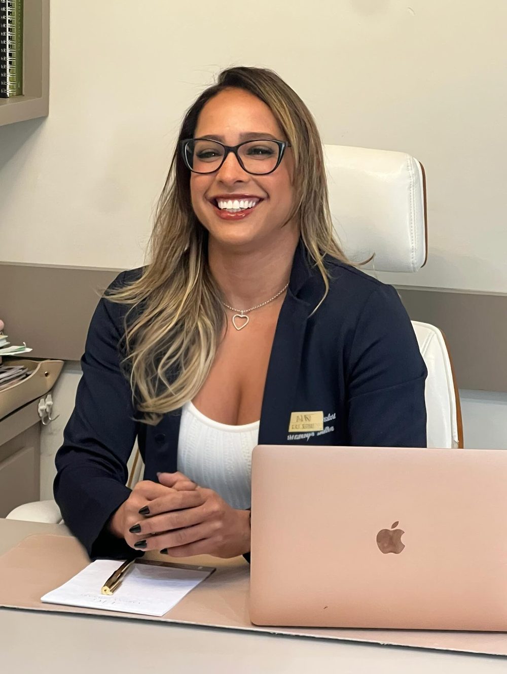 Dra. Dyene Oliveira sorrindo no consultório.